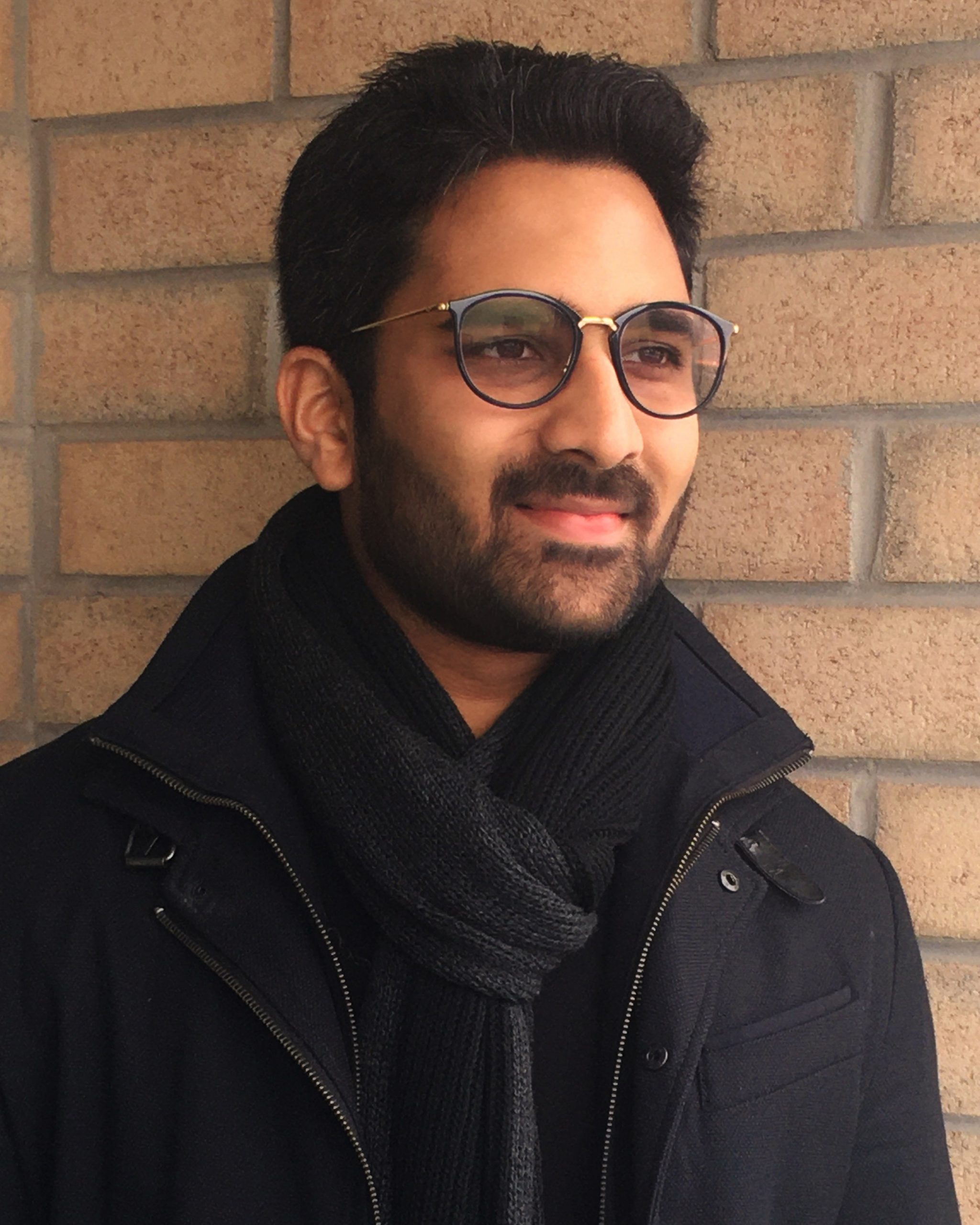 Headshot of a man in front of a brick building