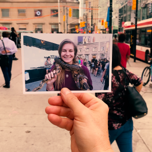 Person holding a photo of a lady in a busy street in downtown Toronto