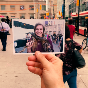 DRUNK ON TOO MUCH LIFE Person holding a photo of a lady in a busy street in downtown Toronto
