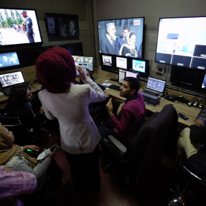 IN THE RUMBLING BELLY OF THE MOTHERLAND A woman talking to a man in a television show control room.
