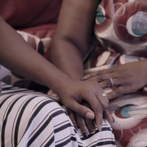 Close up shot of two people holding hands.