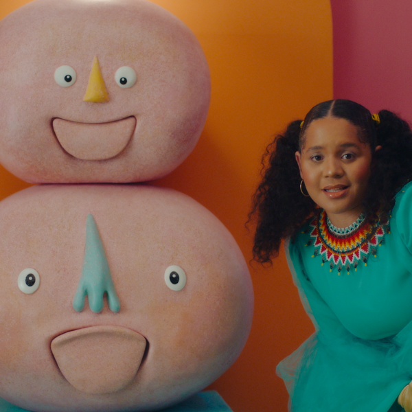 LIDO TV A woman wearing a teal shirt sits beside three large cartoon looking heads