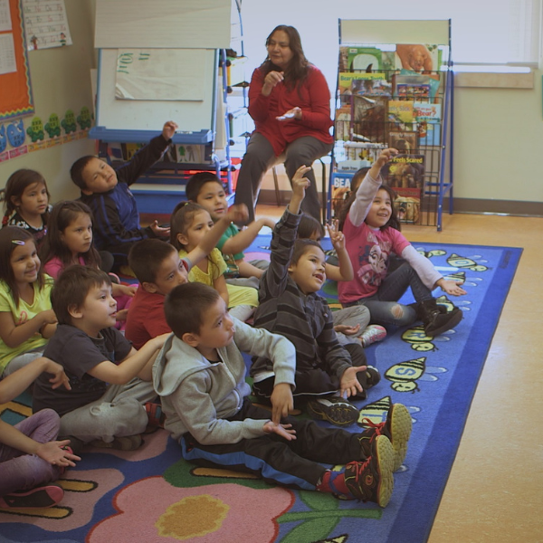 OUR PEOPLE WILL BE HEALED A group of young kindergarten students sit on a carpet in a classroom